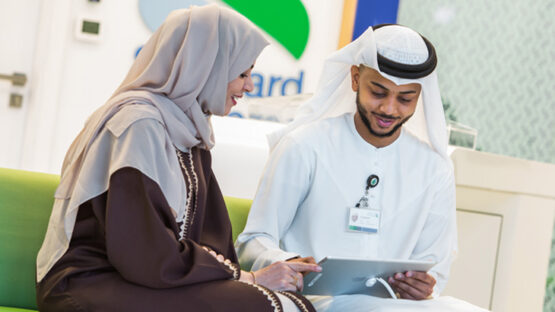 Staff member helping an Islamic Banking client using an iPad