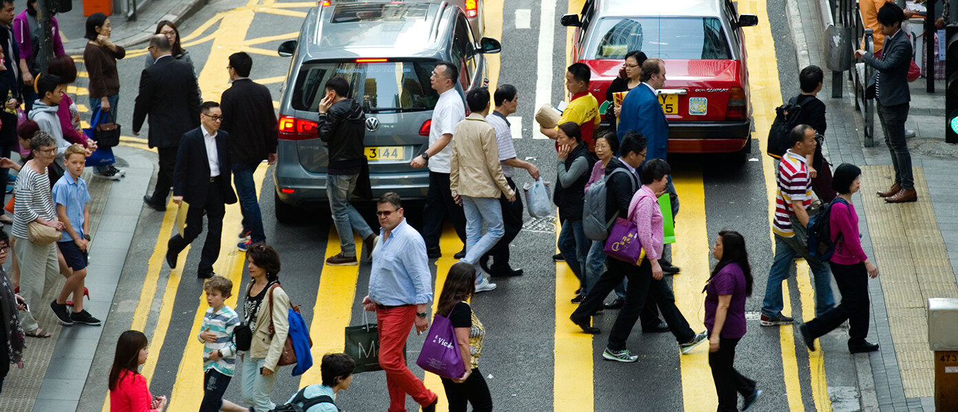 people crossing road in midst of traffic