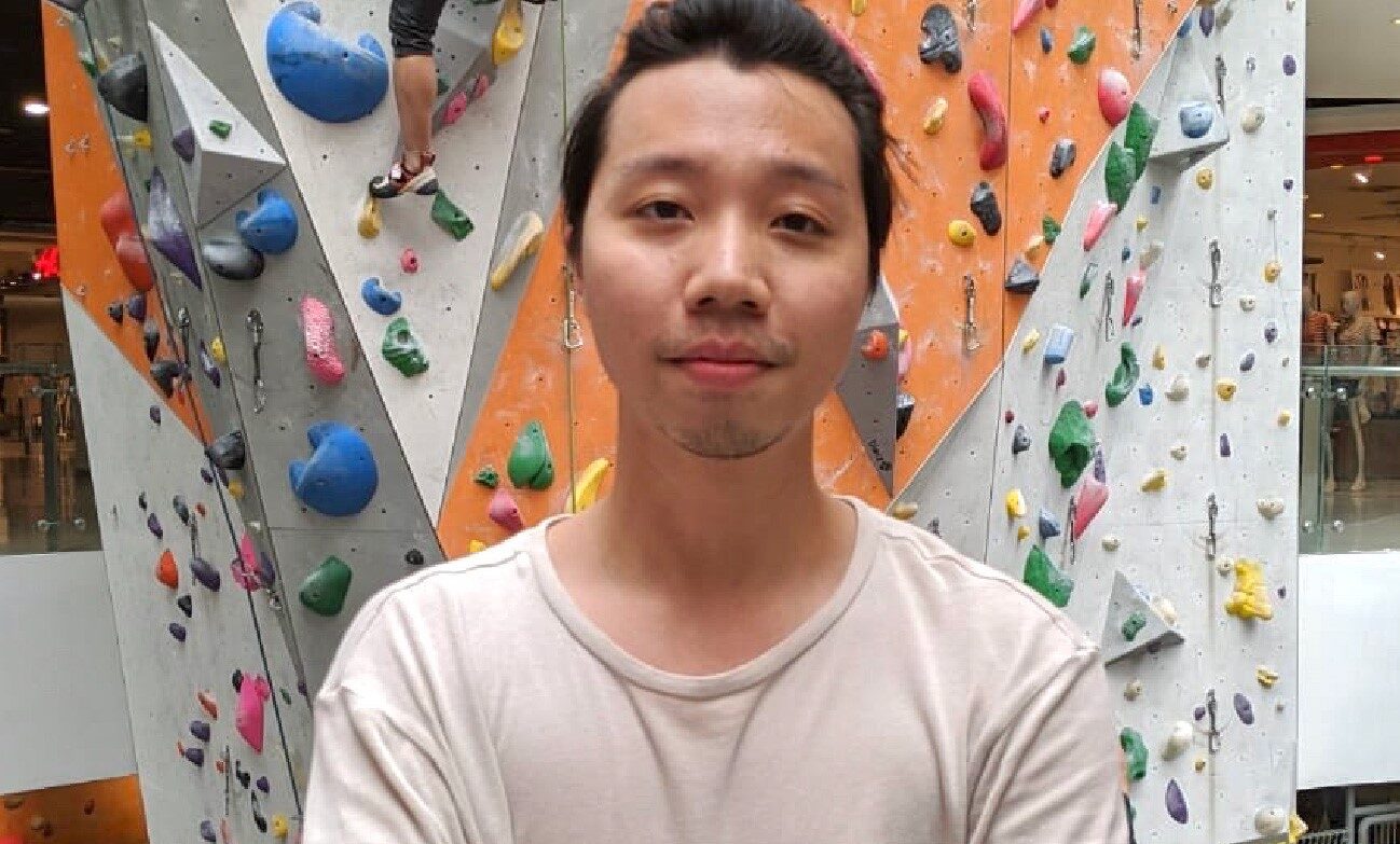 man standing in front of climbing wall