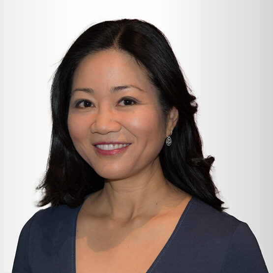 A headshot of Linda Yueh against a grey background.