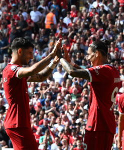 Liverpool players high five to celebrate a goal.