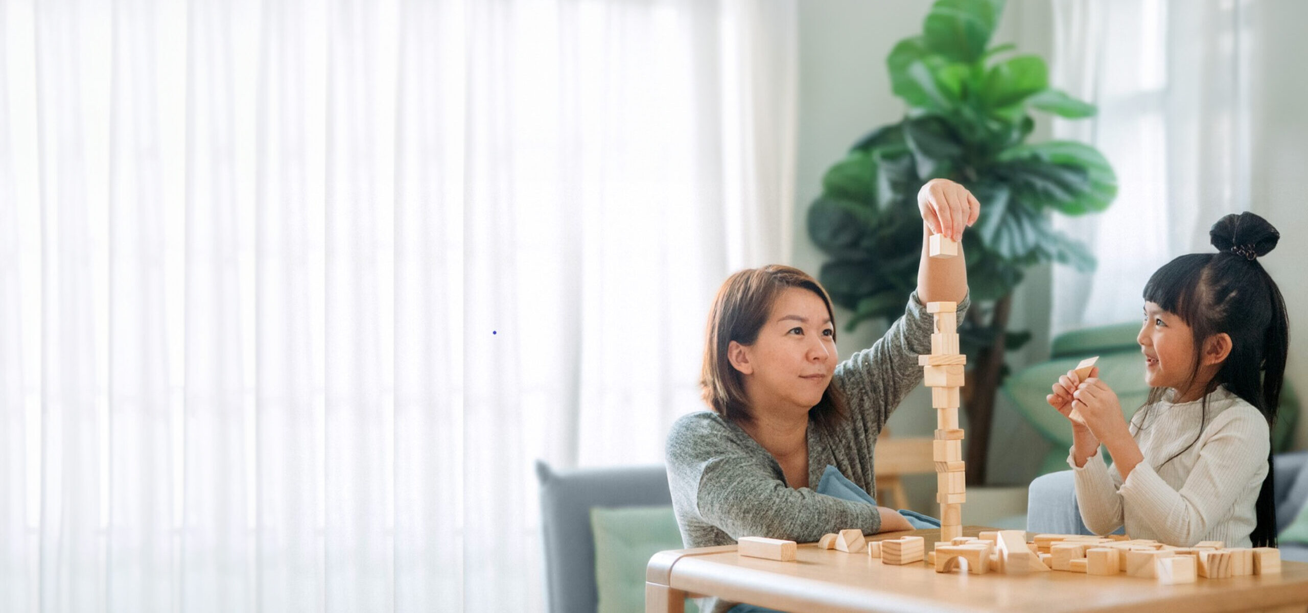 Wealth management: Mother and child playing with wooden blocks