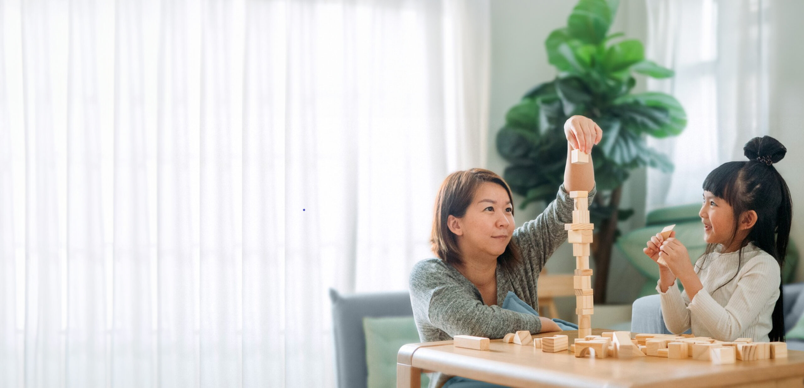 Wealth management: Mother and child playing with wooden blocks