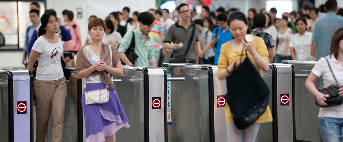 people passing through gates at train station