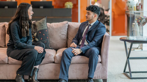 two workers talking on a sofa