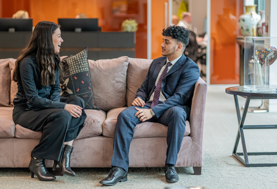 two workers talking on a sofa