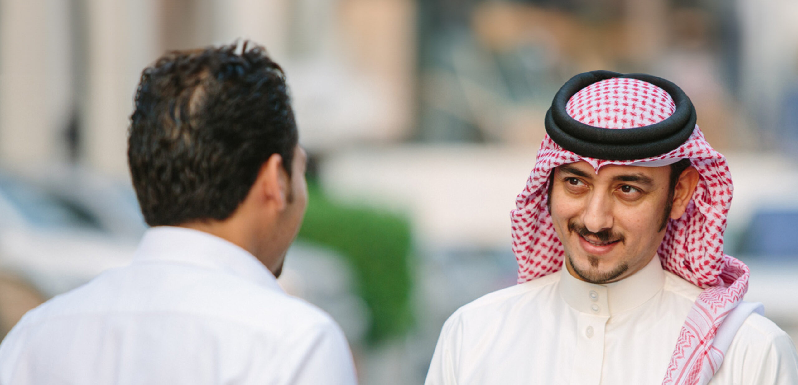 Two businessmen discuss banking in the street.