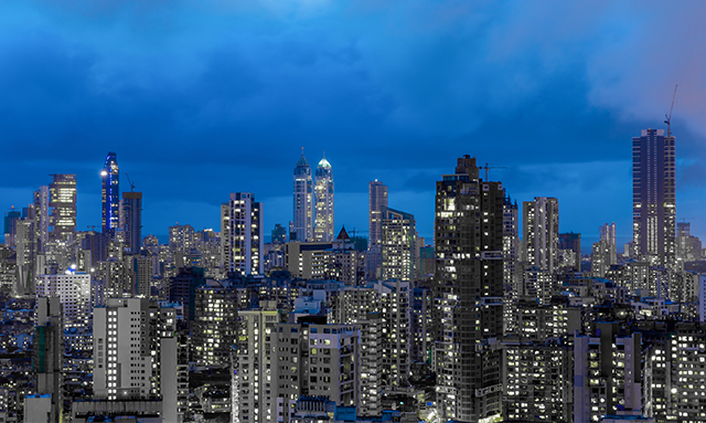 A city skyline under a blue sky reflecting the rise of the global Indian.
