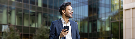 A man smiles while reviewing documents on his phone.