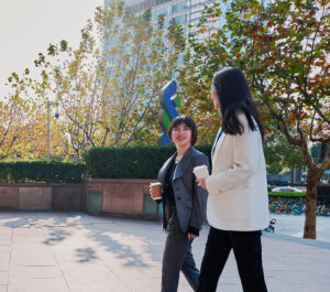 Two Standard Chartered colleagues have a conversation outside an office