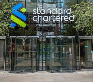 Two colleagues chat outside the London HQ of Standard Chartered