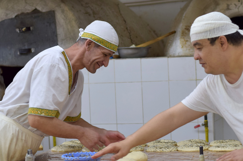 Two men work together in a small bakery in Uzbekistan.