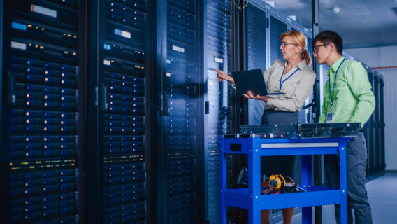 Two people work in a data center.