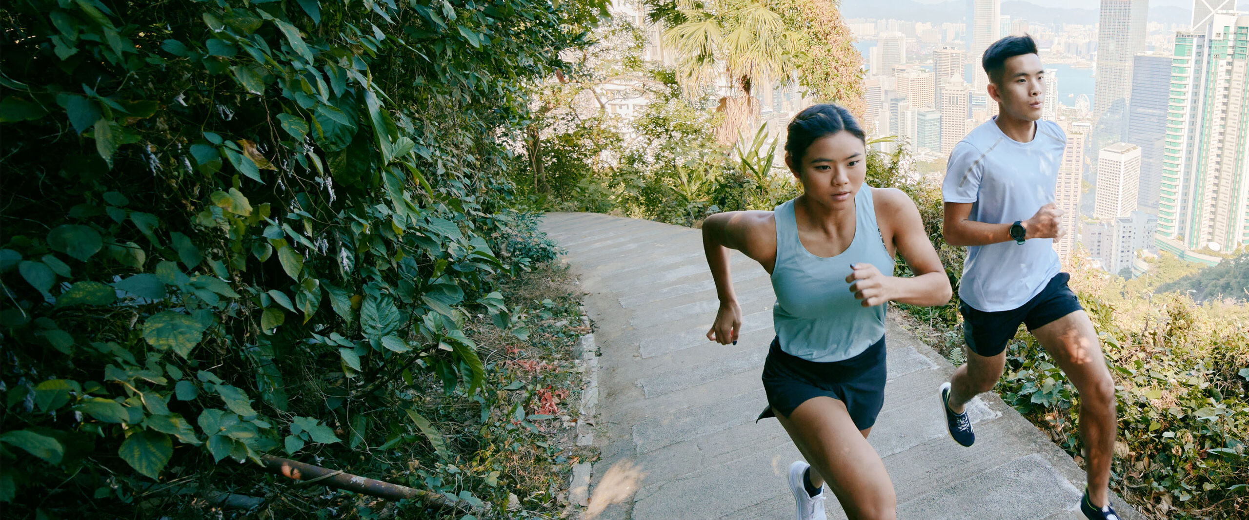 Two runners above the city skyline.