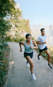 Two runners above the city skyline.