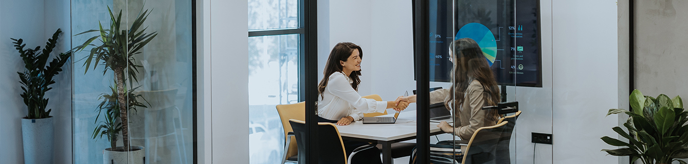 Two women work on a sustainable finance deal.