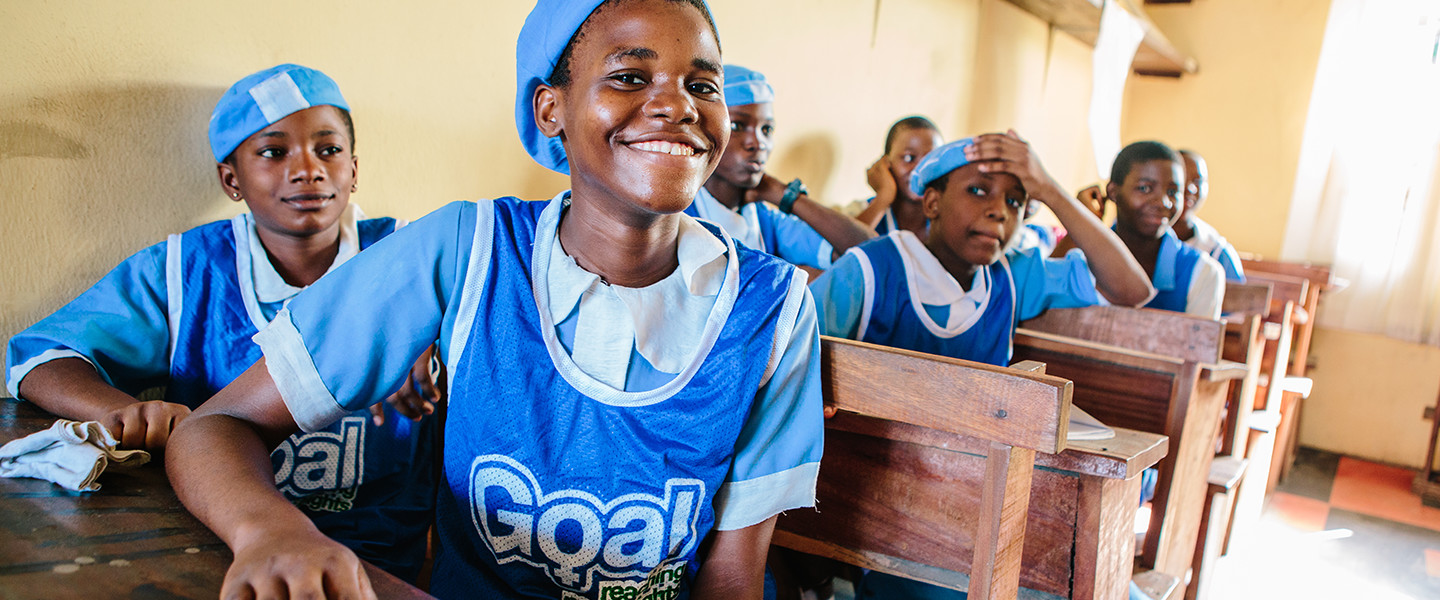 children wearing blue sat in classroom