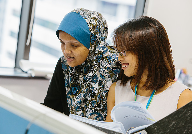 2 women working together at computer