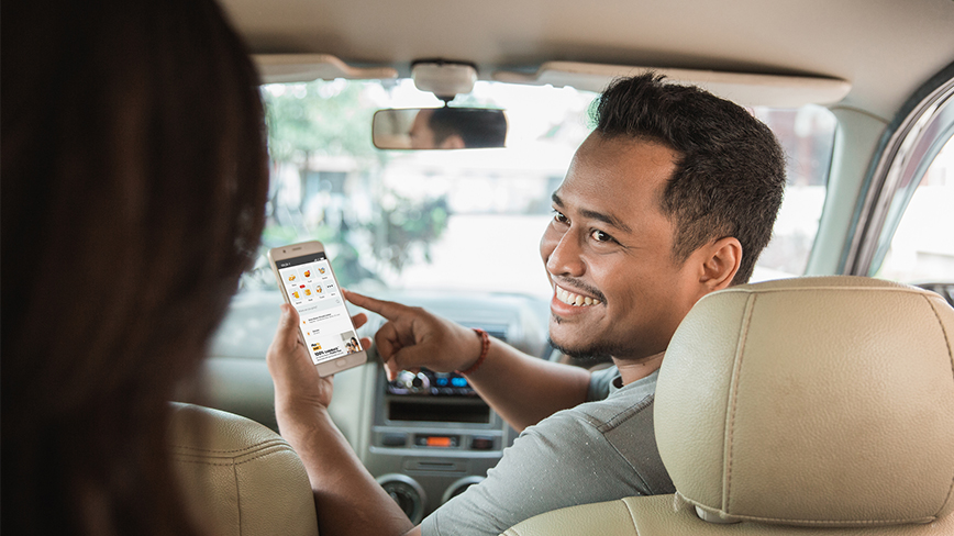 Asian driver looking back at passenger to chat