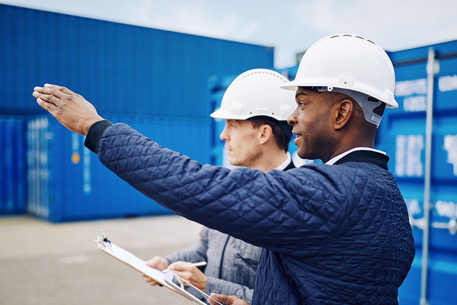 Two men in hard hats discuss globalisation.