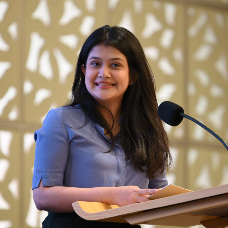 A smiling girl talking over the microphone