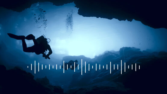 divers swimming in an underwater cave