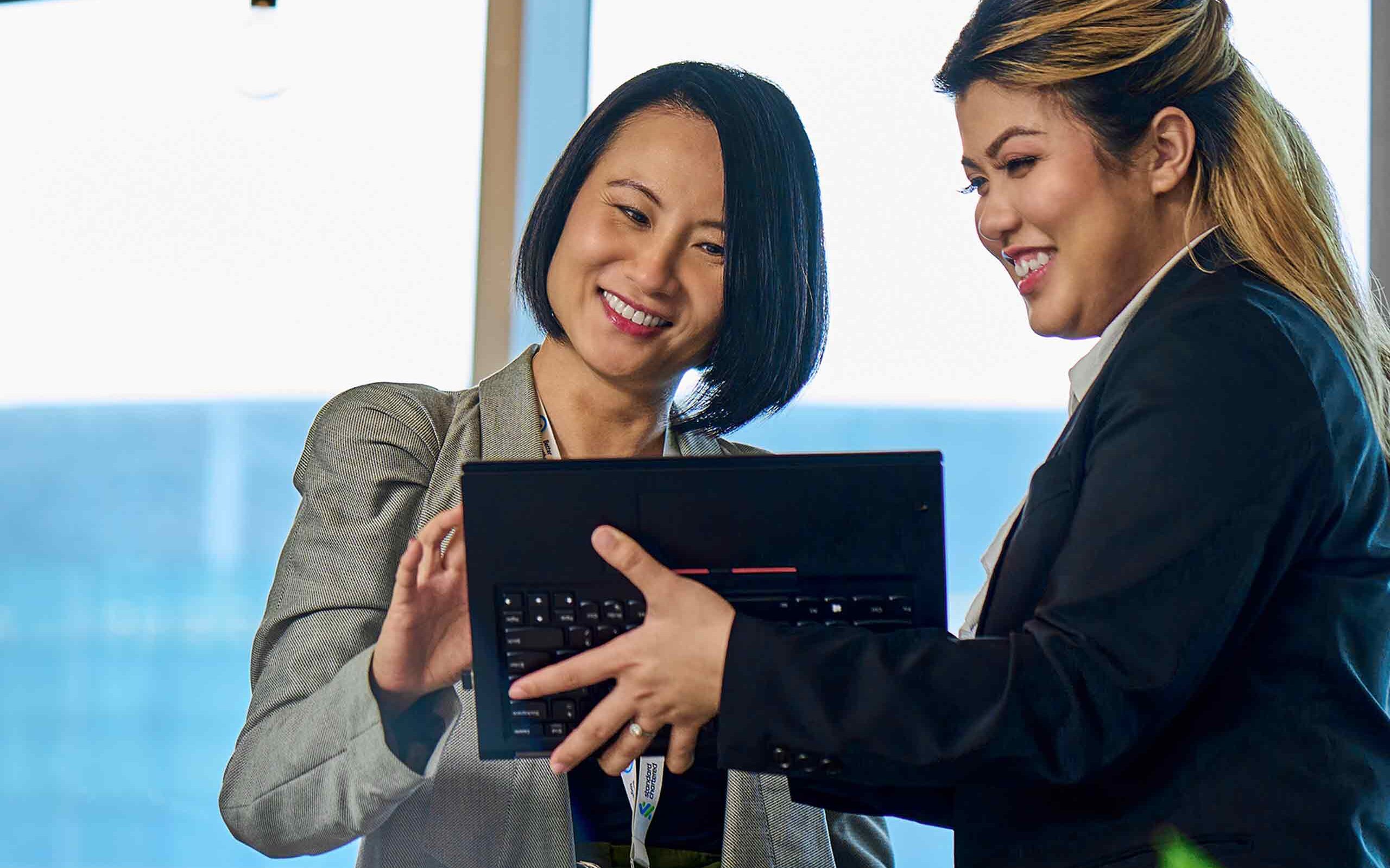 two Standard chartered female employees smiling 