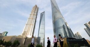 Man walking below skyscrapers