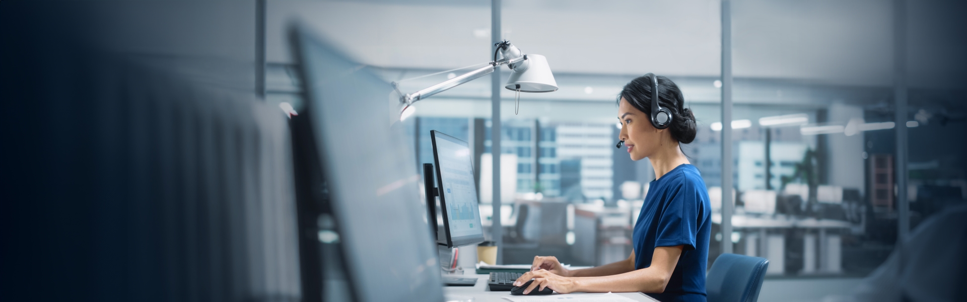 Woman with headset on working on computer