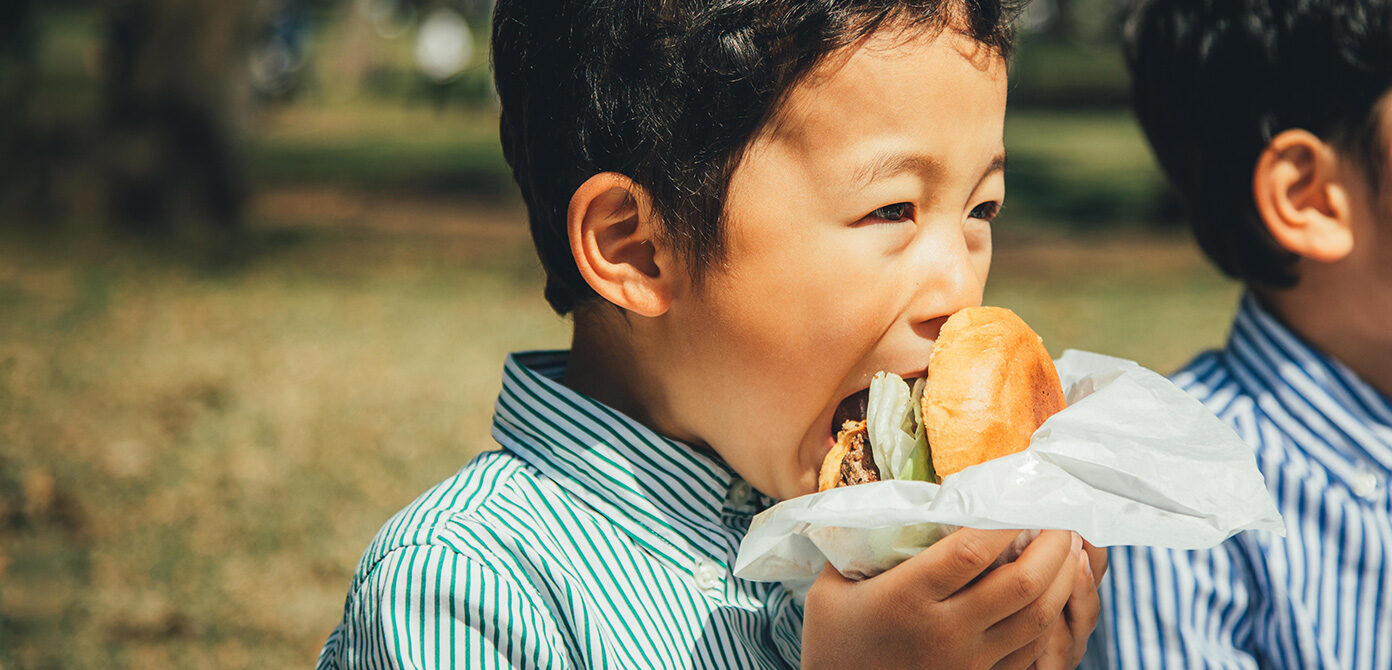 A child biting into a burger