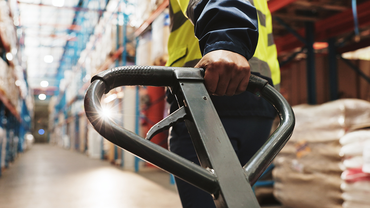 Factory worker pulling a trolley