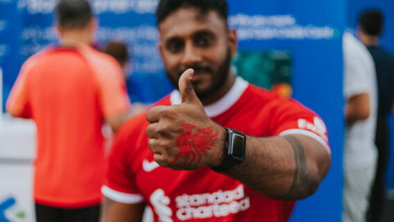 A fan gives a thumbs up with a red liver bird painted on his hand.