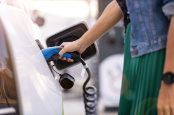 person charging electric vehicle