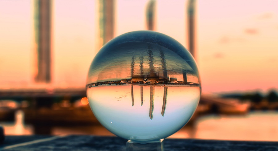 a crystal ball showing the reflection of the city view by the sea