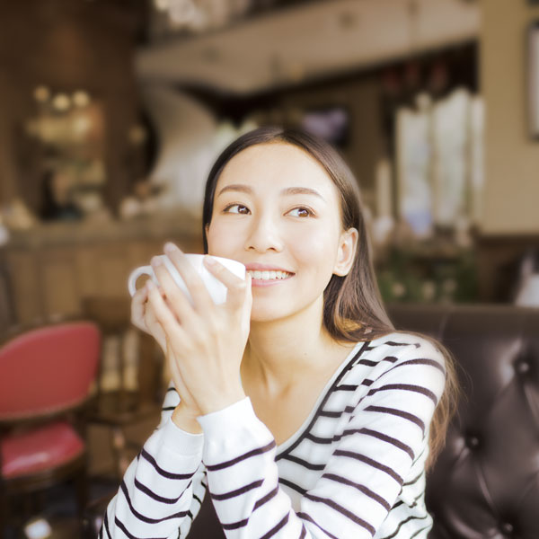 a lady holding a coffee cup in a cafeteria