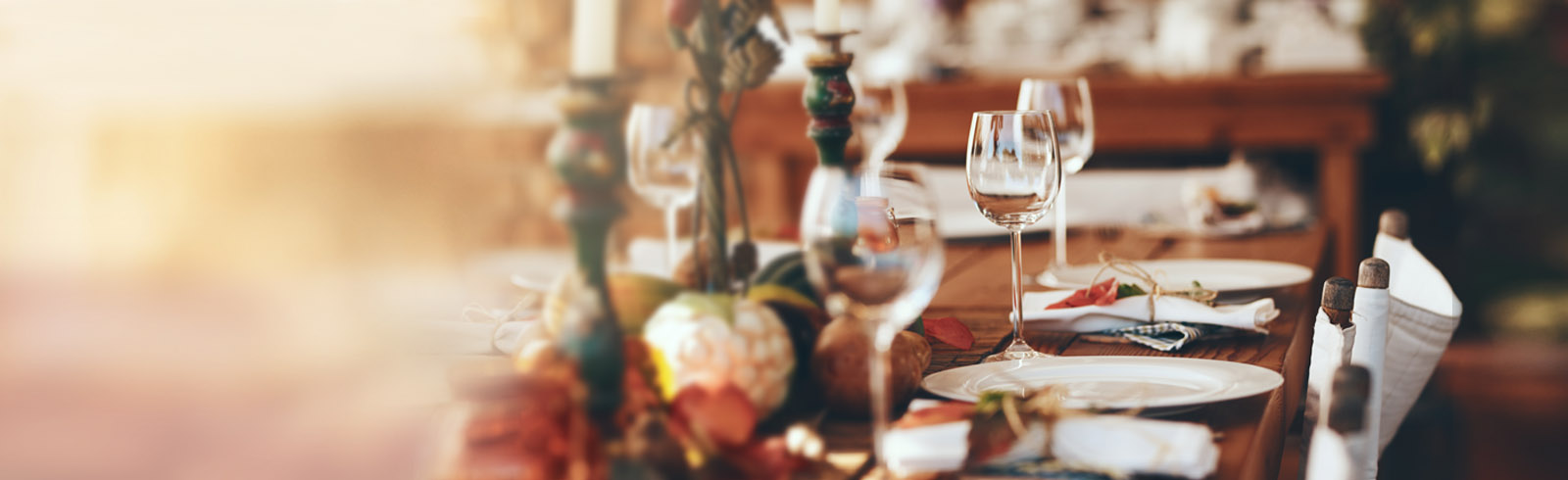 a banquet table with candles, goblets and dishes on it