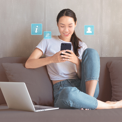 Young woman on sofa using her mobile to update contact and information easily