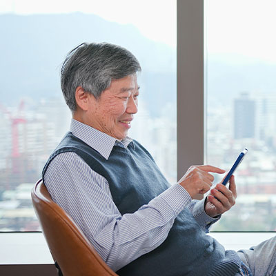 A silver-haired investor using phone in the office