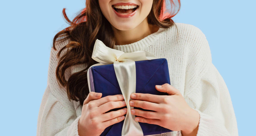 A lady in white sweater feeling ecstatic upon receiving a gift