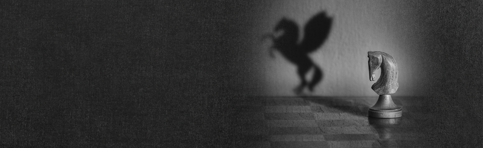 Shadow of a Knight on the chessboard transforming into a flying horse
