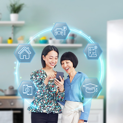 two cheerful ladies using mobile app, surrounded by digital images of house, car, education, etc.