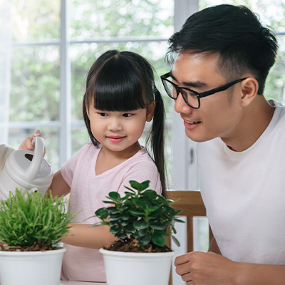 Father are teaching his daughter to learn the education activity for child by planting