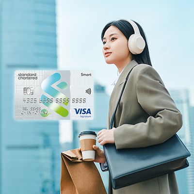 Lady holding coffee and listening to headphones, used to promote SC Smart Card