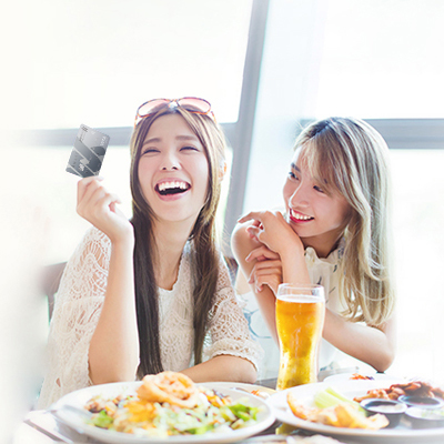Two young ladies are dining and taking the standard chartered smart card