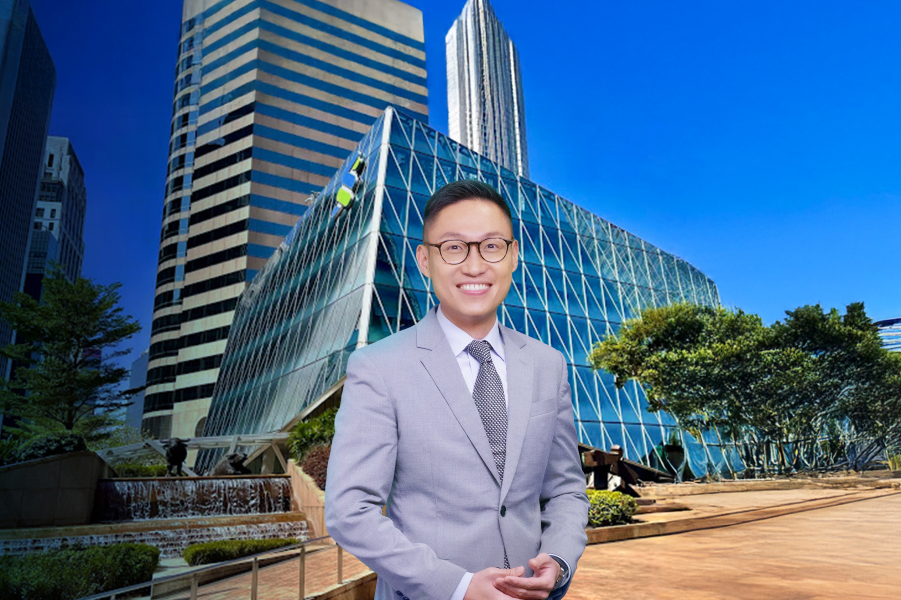 A man in front of the Standard chartered Office building.
