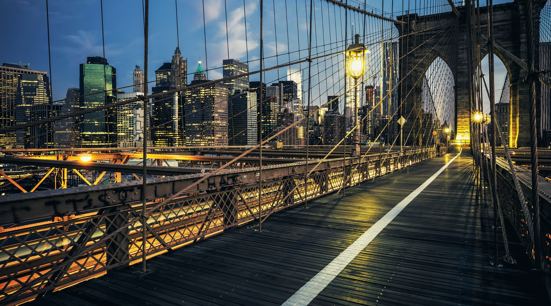 Night view of Brooklyn Bridge with New York metropolis background