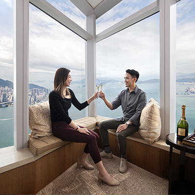 一對情侶在擁有海景的酒店房間享受香檳