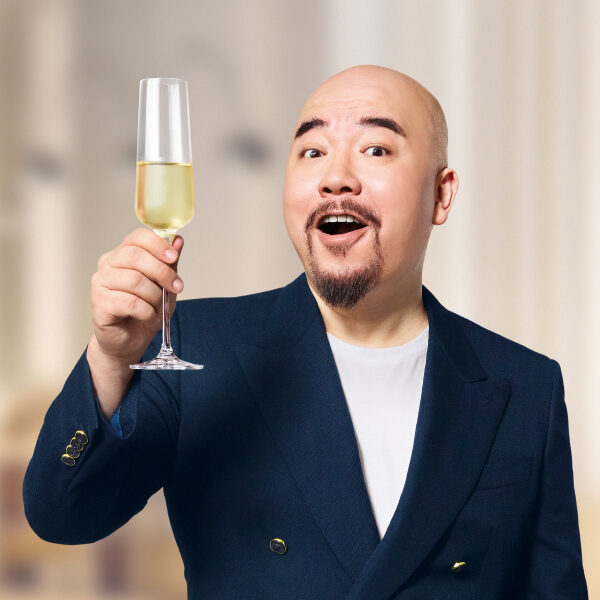 Wyman黃偉文身著深藍色西裝舉起香檳慶祝