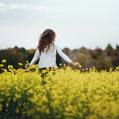 一位女士在種滿黃色花的花田中央