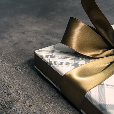 一個用金色緞帶綁著的格紋禮物箱